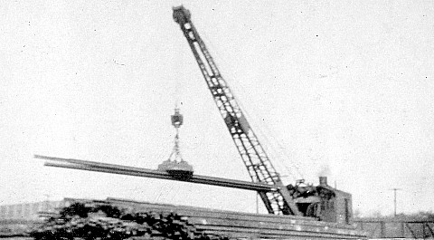 Steam-operated, magnetic crane unloading worn rails at the McKenna Process Company about 1917 - George Langford, Jr. photograph